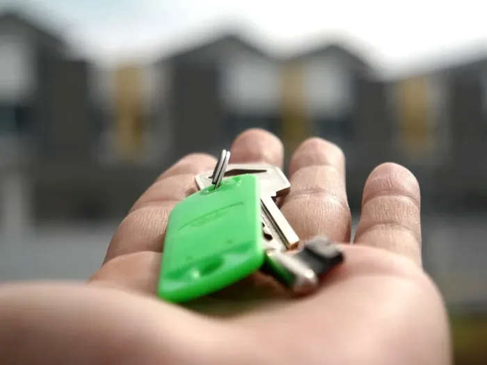 Une clé de maison tendue dans une main